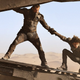 Josh Brolin's Gurney Halleck grabbing Timotée Chalamet's Paul Atreides to keep him steady on the landing ramp in a scene from Dune.